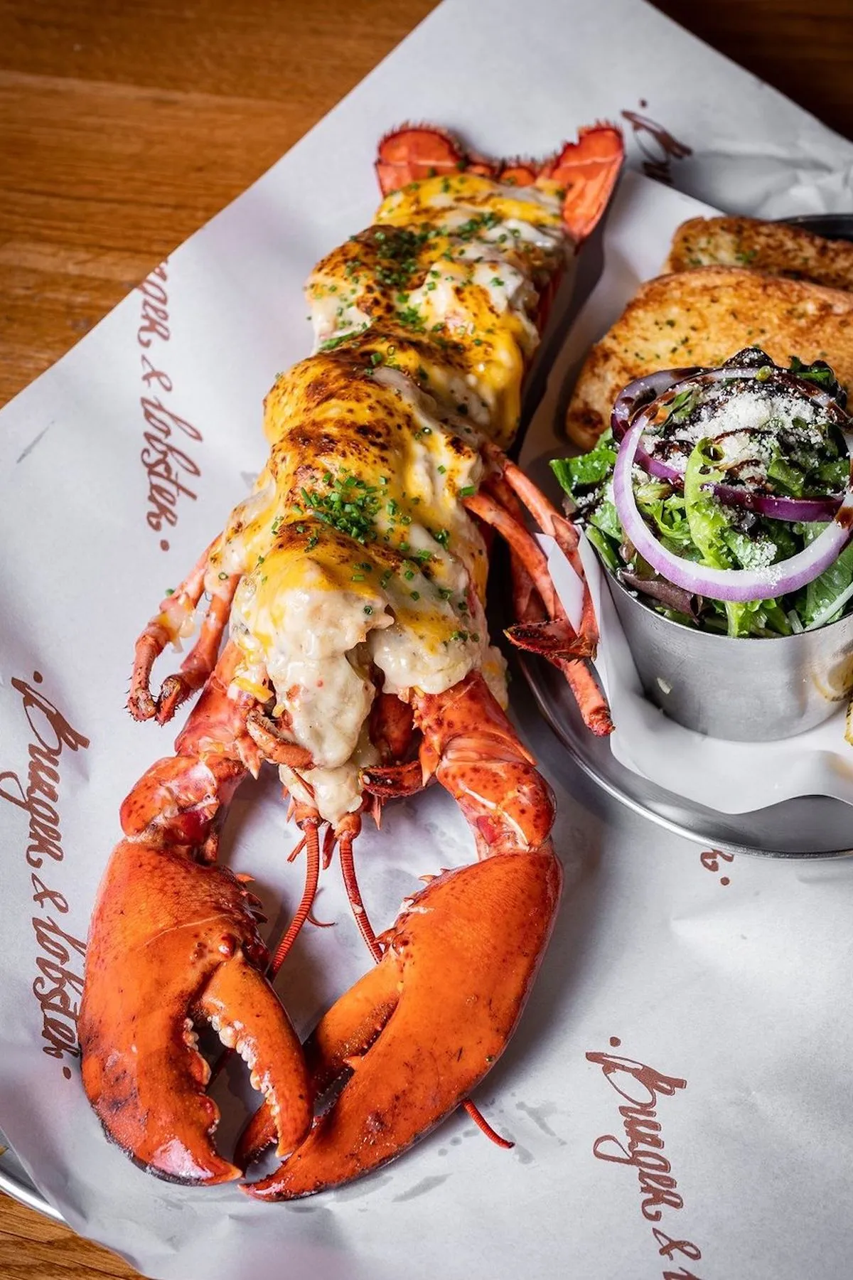 A baked lobster with special sauce with garlic bread and a salad in a restaurant in Bangkok