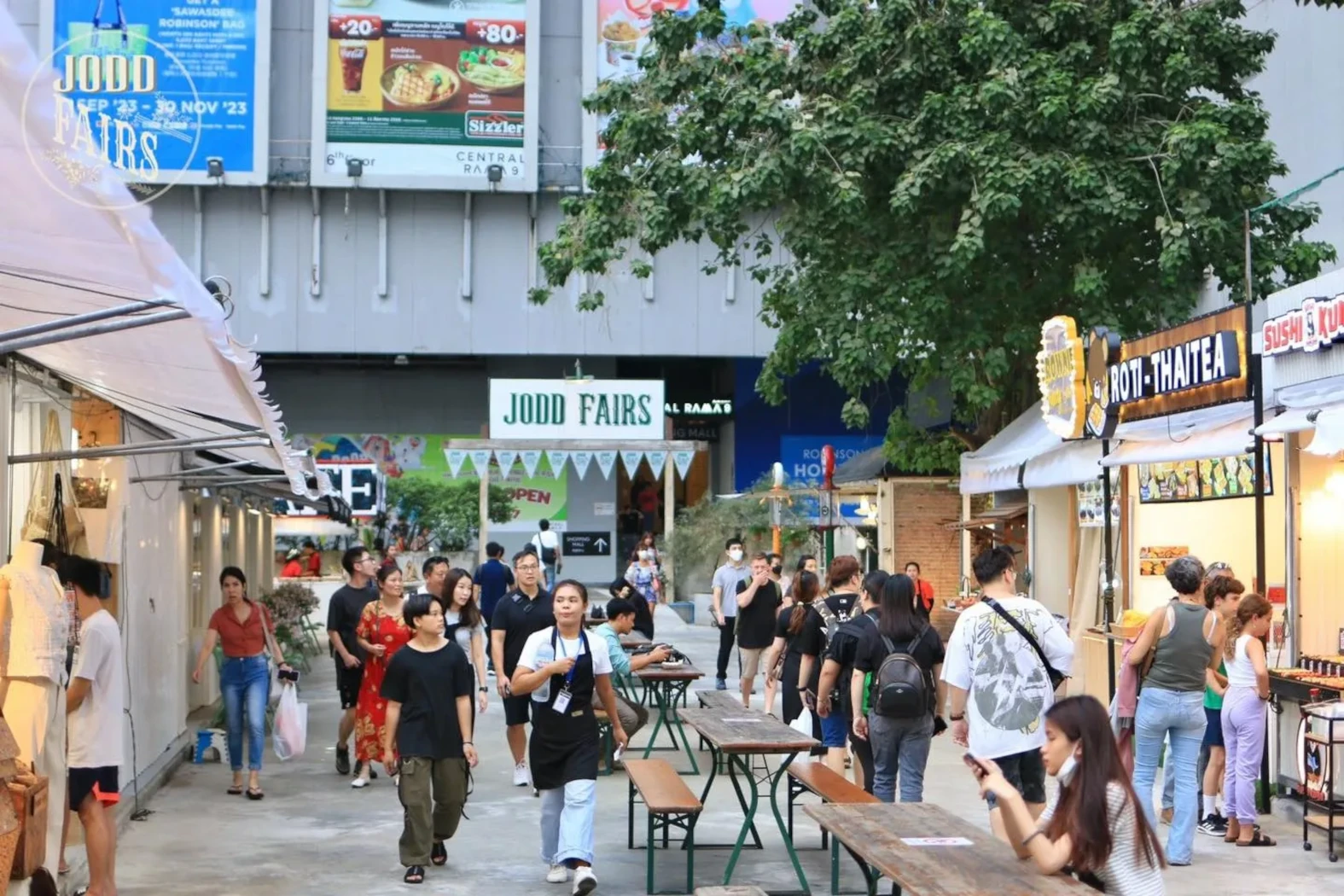 Jodd Fairs night market in Bangkok with people walking.