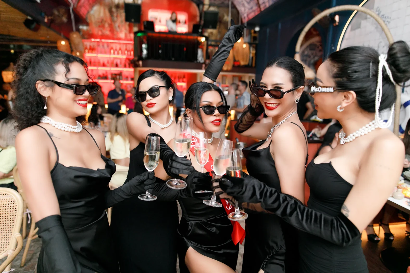 Girls enjoying a hen night, smiling and drinking champagne at Pastel rooftop bar in Bangkok