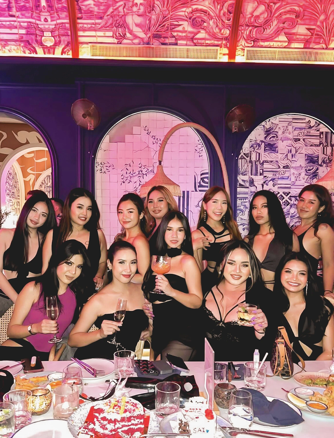 group of beautiful girls holding drinks and smiling while celebrating a hen night at Pastel Bangkok