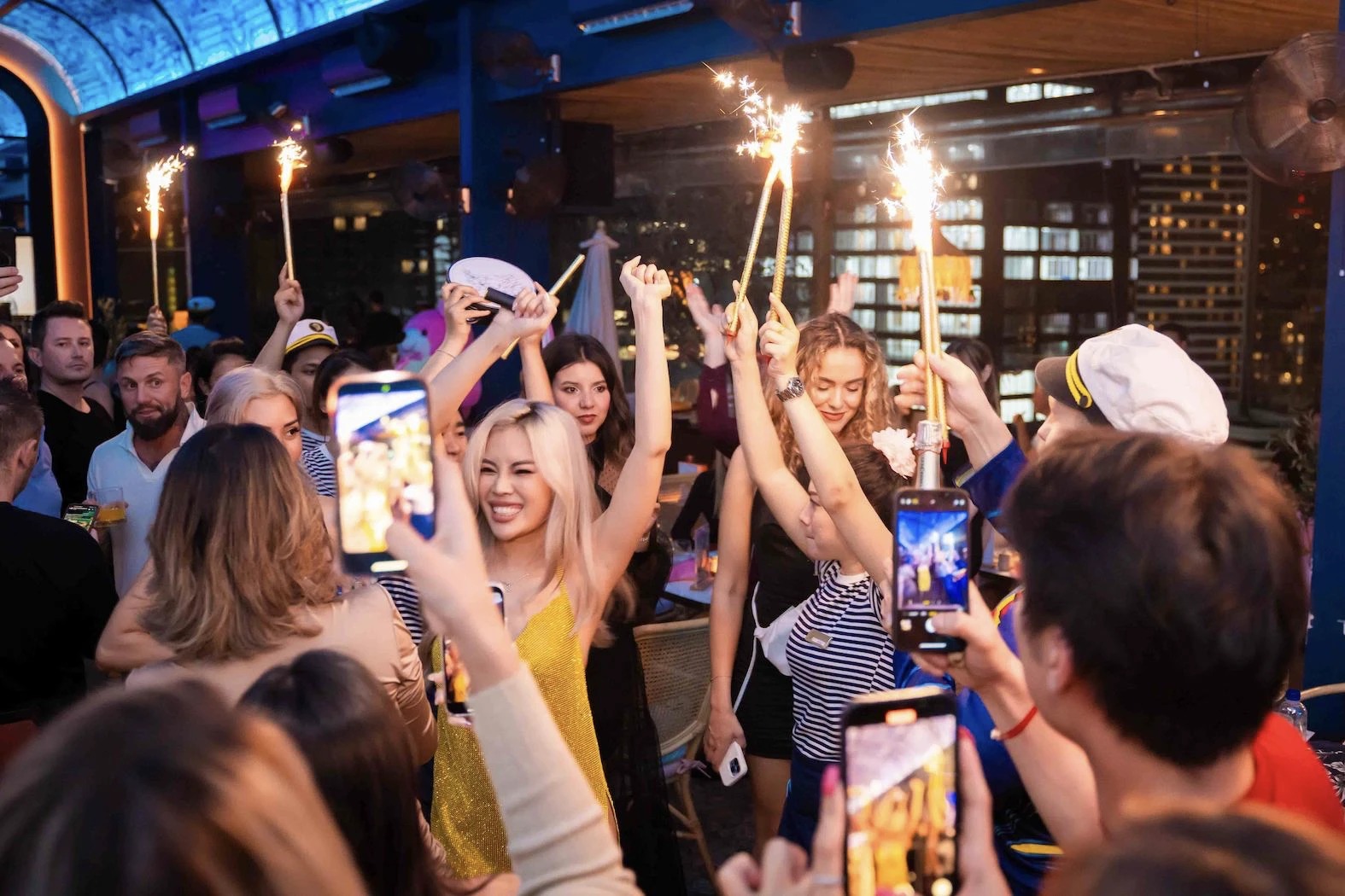 group of people partying and putting sparklers in the air at Pastel Bangkok party restaurant and rooftop bar in Thailand