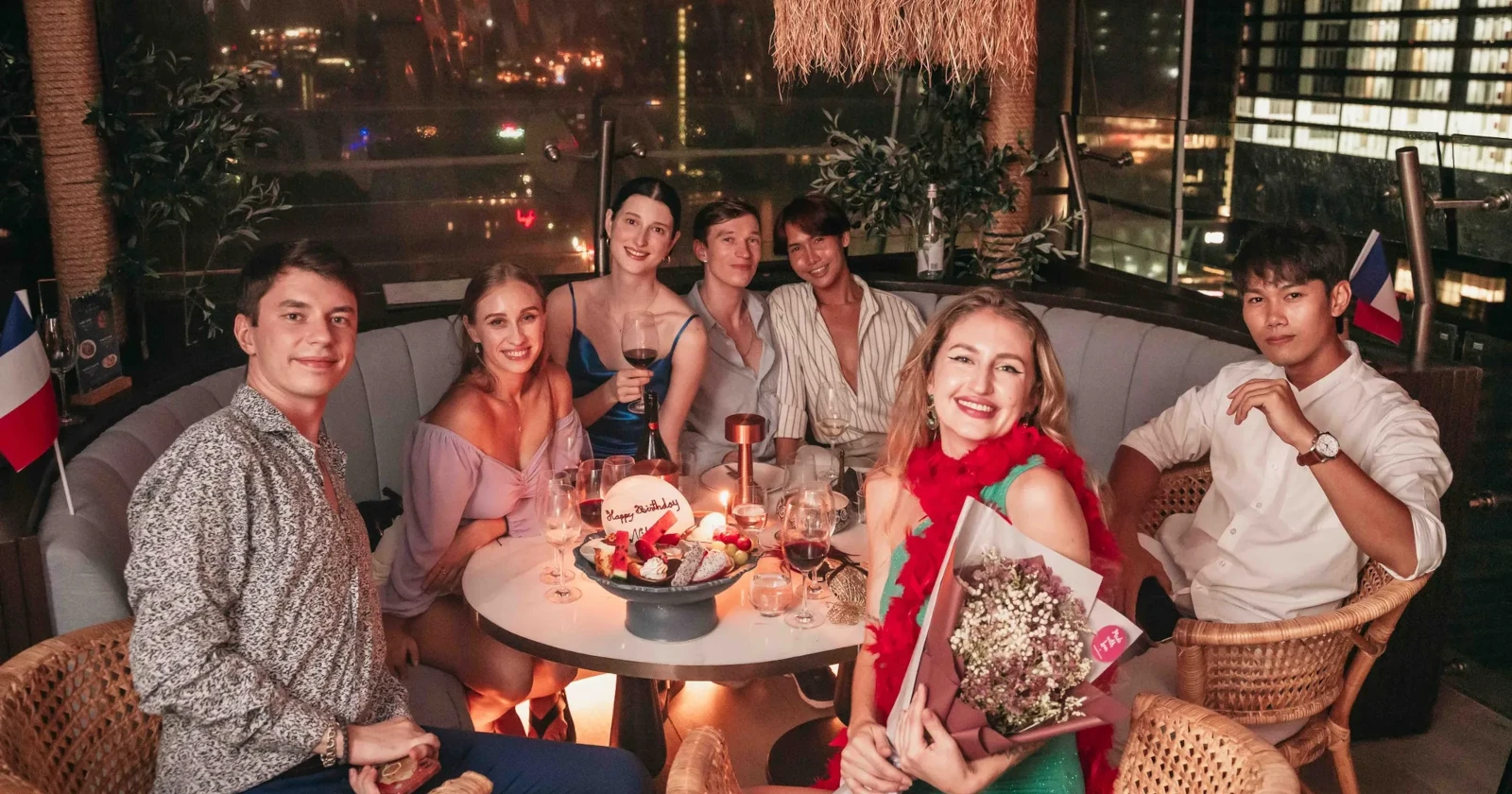Joyful group of friends posing for a photo at Pastel Rooftop in Bangkok, enjoying party.