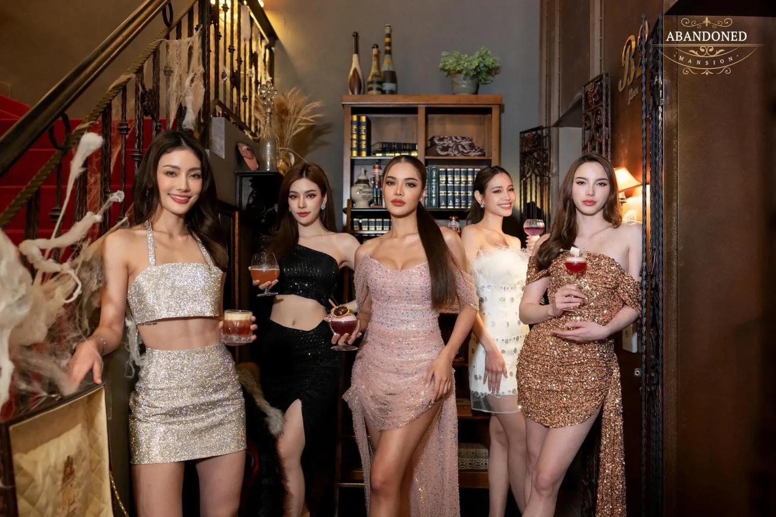 A group of stunning girls, elegantly dressed, posing for a photo at Abandoned Mansion Bangkok.
