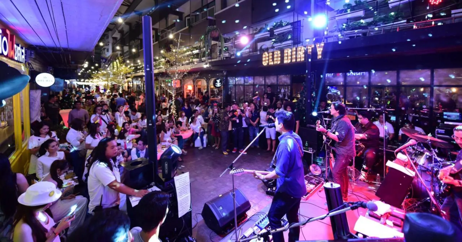 People enjoying a live band performance at a live music bar in Bangkok, Thailand.