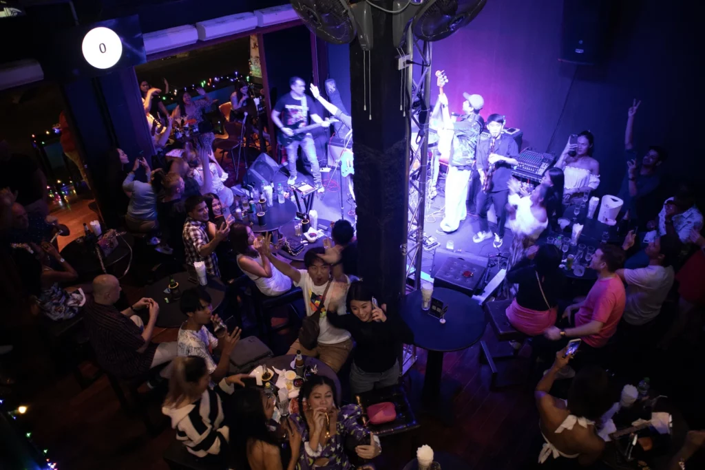 live band playing and crowd cheering at a live music bar in Sukhumvit soi 11 in Bangkok