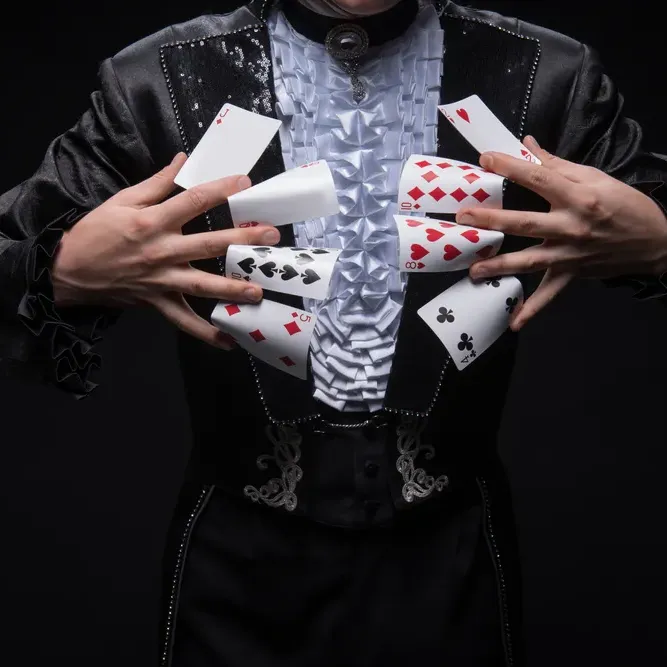 A magician performs an elegant card trick at Pastel Bangkok, skillfully fanning playing cards.