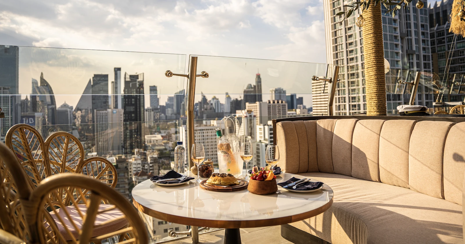 outdoor table with wine and bites during the sunset at Pastel Bangkok rooftop bar and restaurant