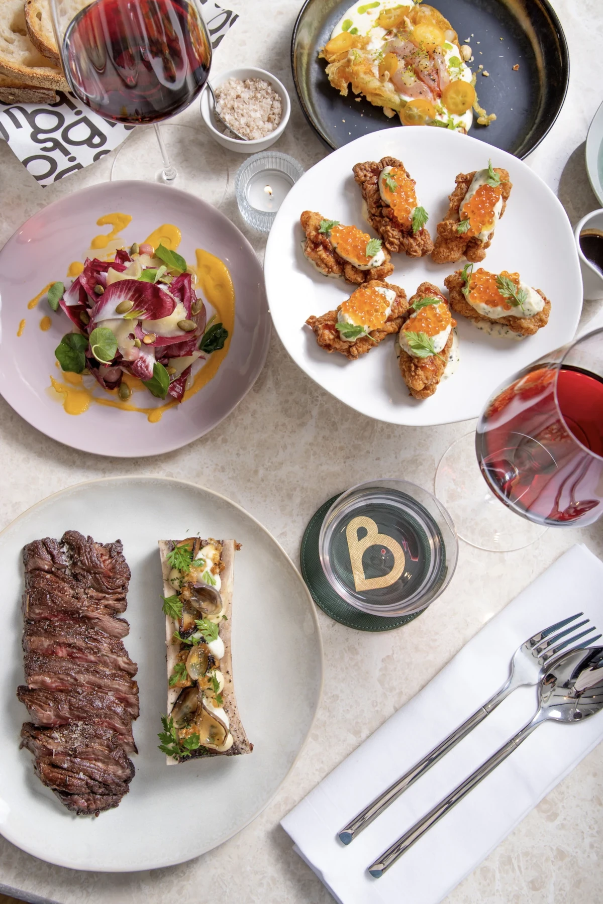 image of a beautifully set table at Bisou Bangkok, a French restaurant with some plates