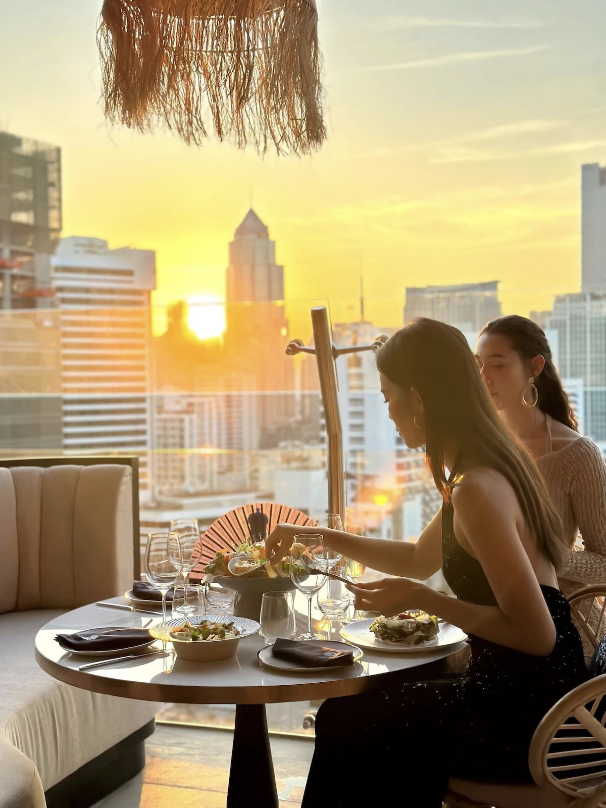 Thai models eating at Pastel Bangkok rooftop bar during the sunset