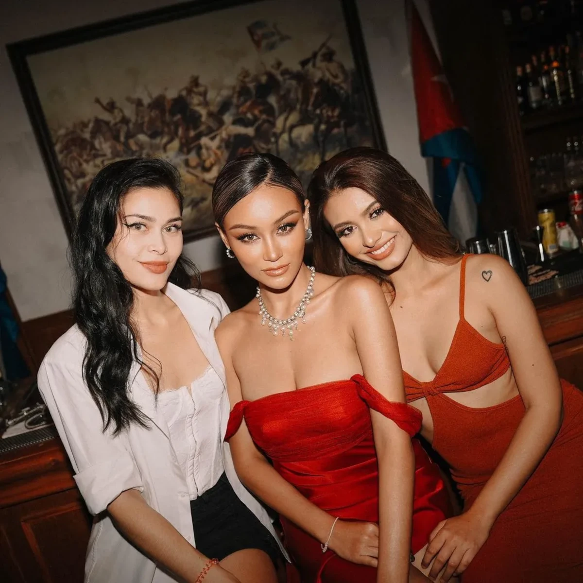 Three stylish Thai girls enjoying a party at a cocktail bar in Bangkok.