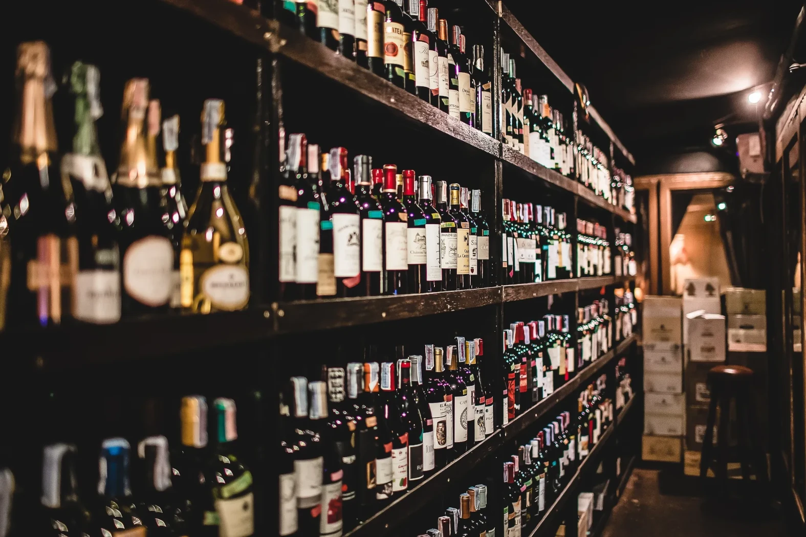 Red and white wine bottles along a wall at the Melting Clock restaurant in Bangkok.